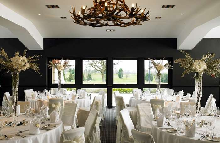 Staverton Suite wedding venue with large windows and decorated tables.